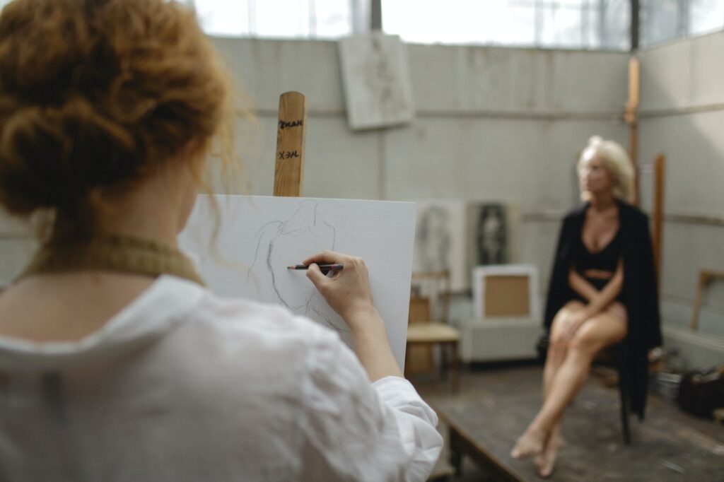 woman sketching on white cardboard