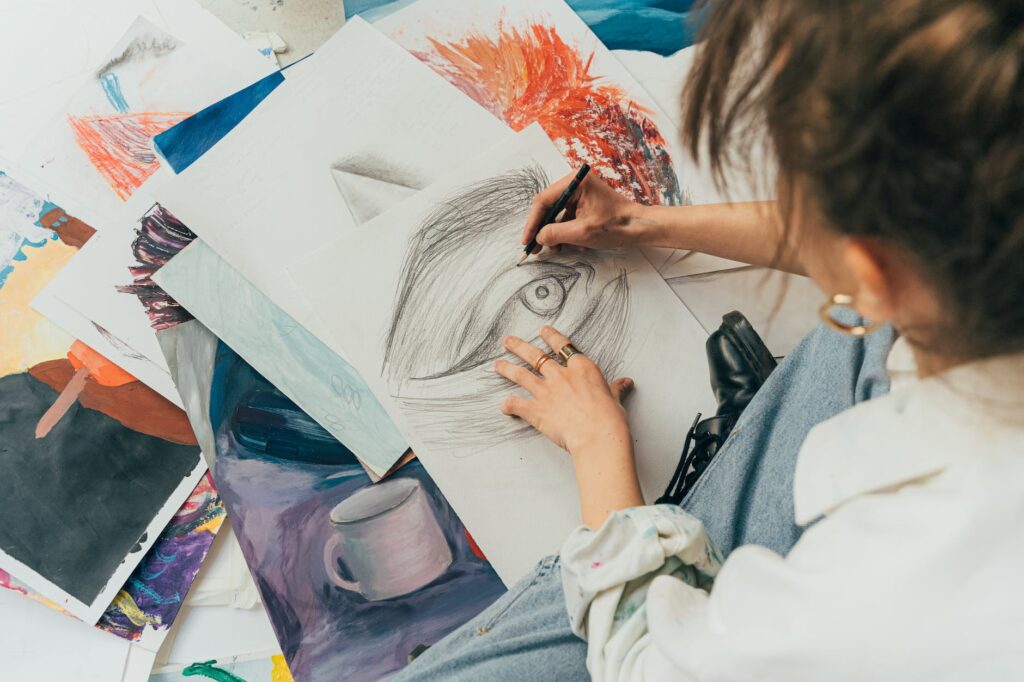 a woman making a drawing on a sketchpad