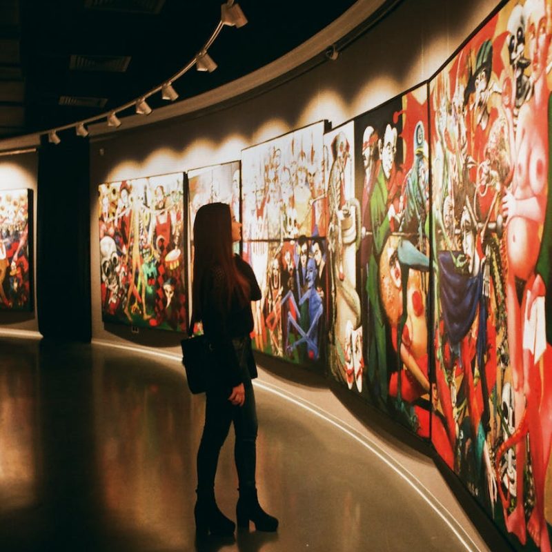 woman standing near paintings