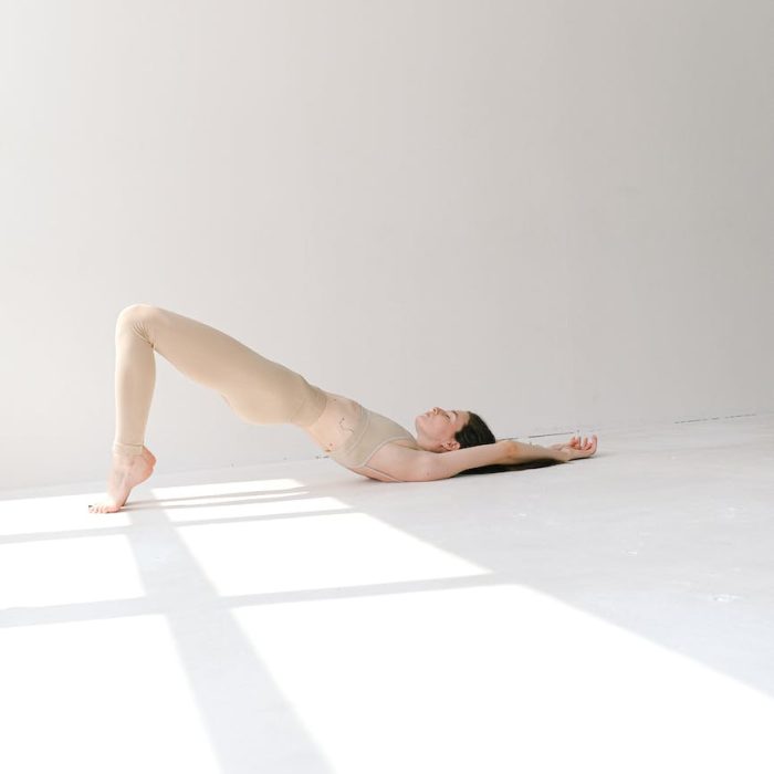 slim woman in bridge pose in studio